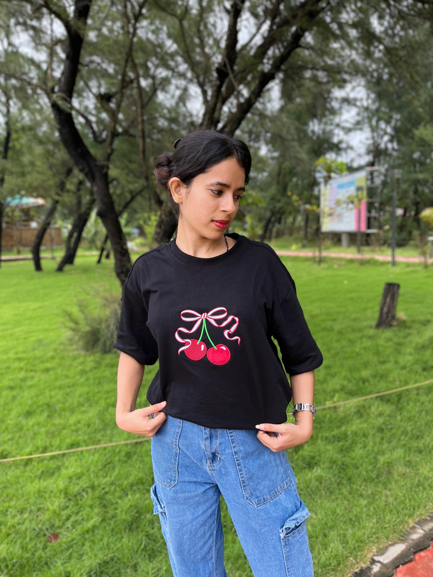 Red cherry in black oversized t-shirt