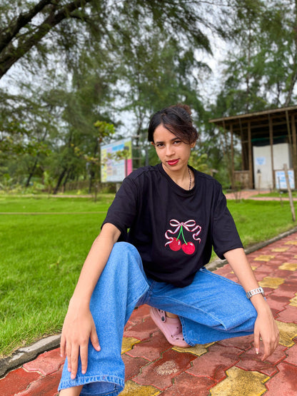 Red cherry in black oversized t-shirt