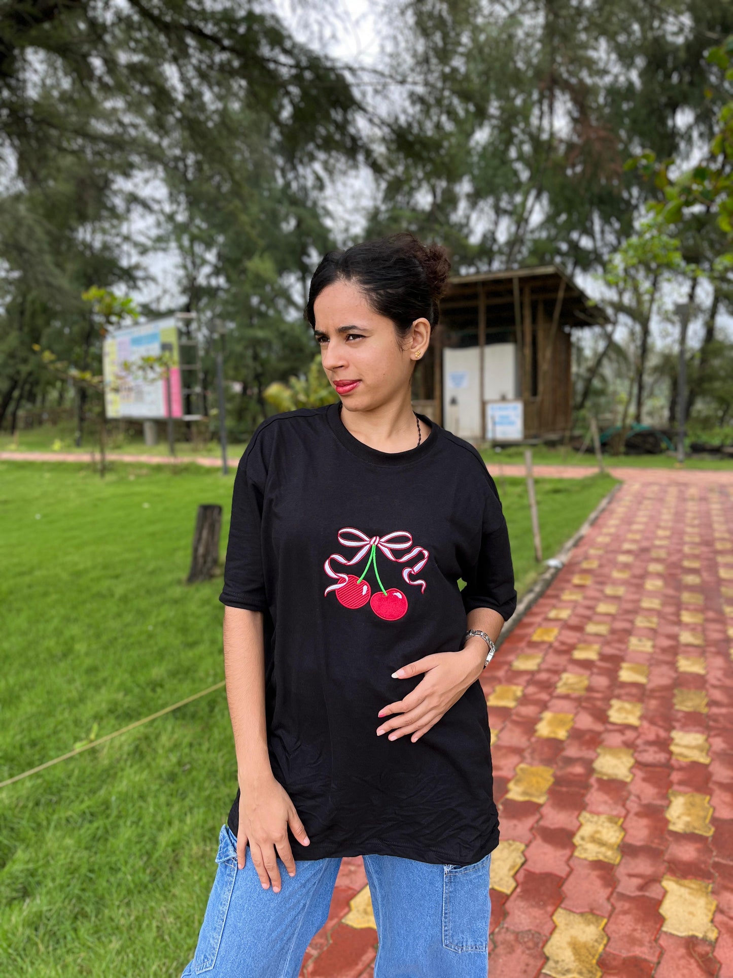 Red cherry in black oversized t-shirt