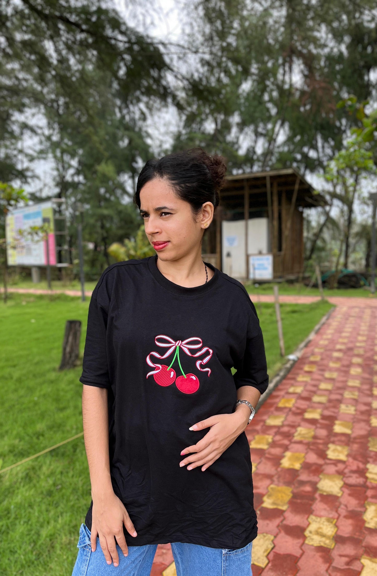 Red cherry in black oversized t-shirt